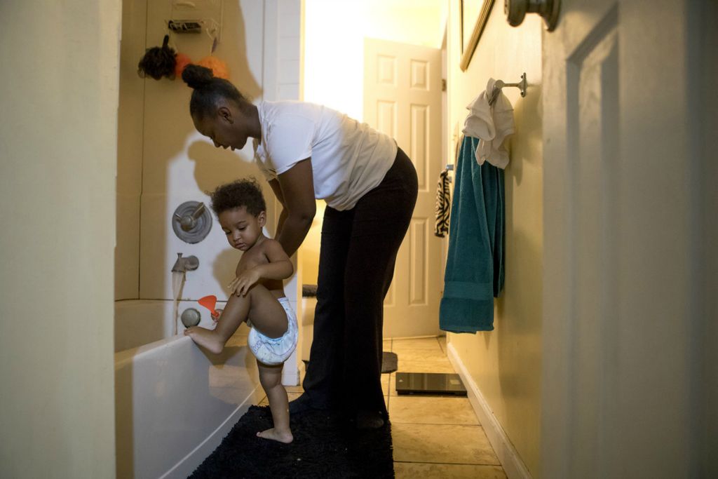 Third Place, Sports Picture Story - Jessica Phelps / Newark Advocate, “Coaching Creates Deep Roots For Croom Family”Tashia Croom holds her son Kendrix as he tries to climb into the bathtub. Tashia and her family balance work, time with each other and still have time to spend at the high school gym where her daughter plays multiple sports and Tashia and her mom and fiancé all coach. 